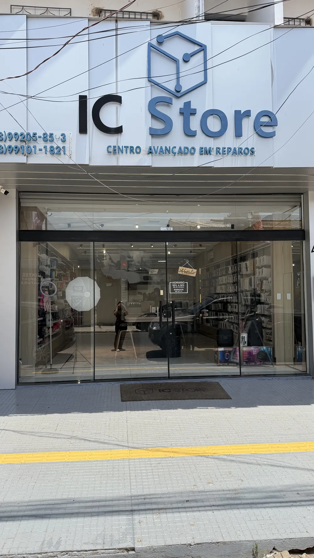 Fachada da IC Store: letreiro com a marca sobre a entrada de vidro, na Travessa Turiano Meira